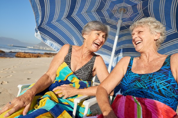 Two senior women enjoy a summer day at the beach.