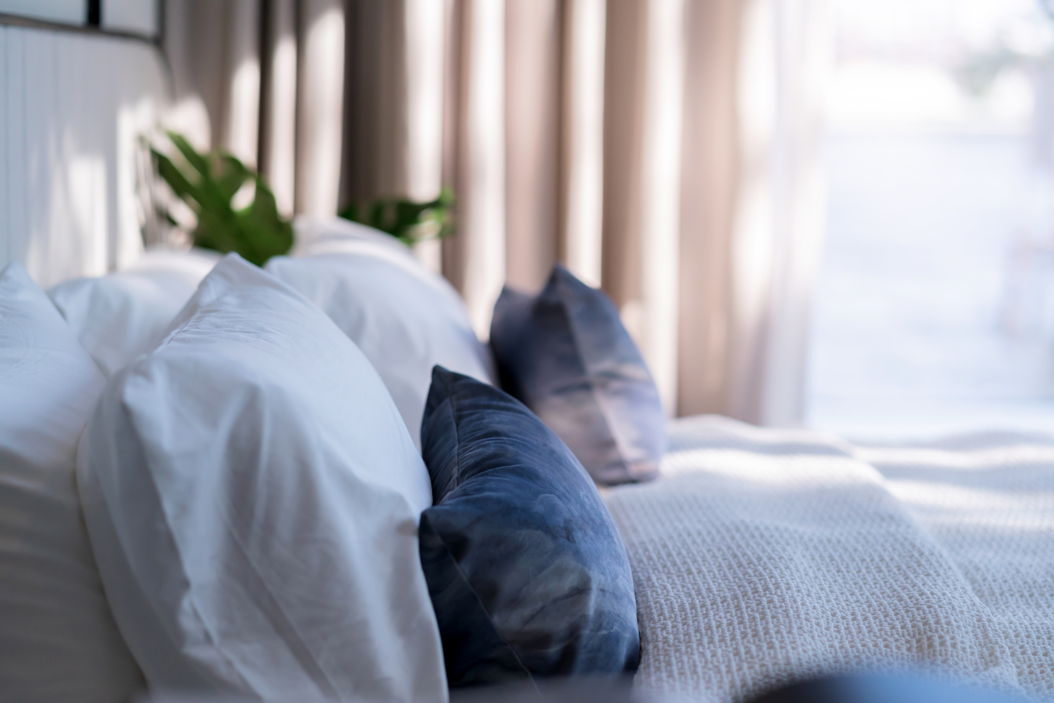 Bed maid up with clean white pillows and bed sheets in beauty bedroom. Close up. interior background