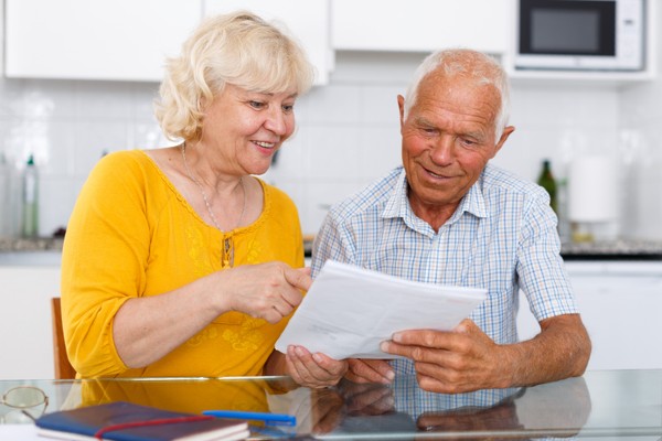 Two seniors review some documents about their health care needs.