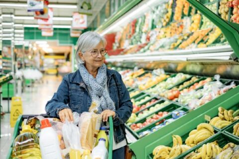 A senior woman shops for groceries.